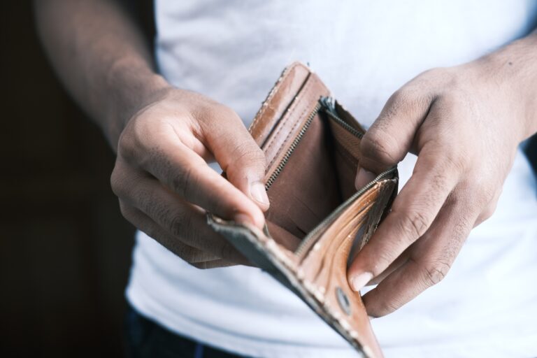 Muž držící prázdnou peněženku